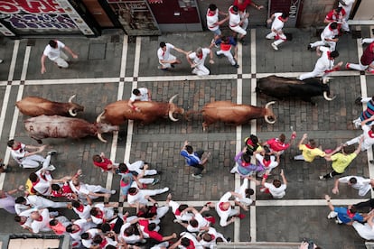 Un grupo de corredores junto a los toros de la ganadería de Domingo Hernández a su paso por la calle Estafeta, este jueves. 