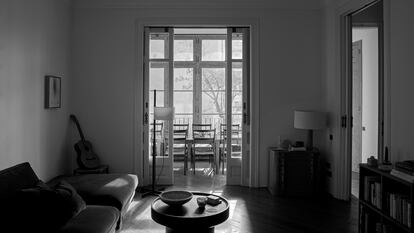 La sala de estar del piso de Helena Agustí Sanahuja, conectada con el corredor mediante unas puertas correderas de cristal que permiten divisar el jardín interior de la finca.