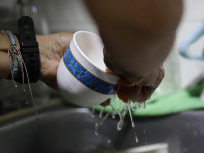 Una mujer lava una taza en su casa este jueves, cuando empezó a racionarse el agua en Bogotá.