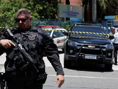 Un agente de la policía brasileña, este lunes ante el cordón colocado para controlar la entrada de la escuela pública donde un alumno ha abierto fuego contra otros estudiantes.