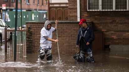 Dos hombres limpian las aguas residuales en Nueva York,