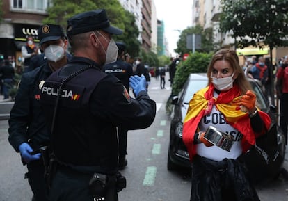 Dos policías se dirigen a una manifestante en la calle de Núñez de Balboa (Madrid).