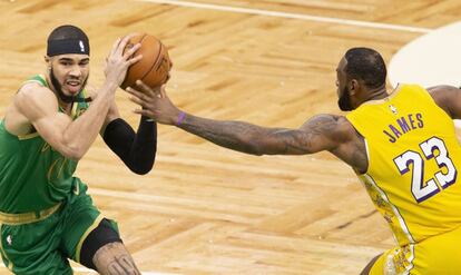 Jayson Tatum trata de zafarse de LeBron James.