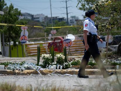 Una policía camina frente a las flores y velas colocadas en honor a los fallecidos en el accidente, este viernes en San Pedro (México).