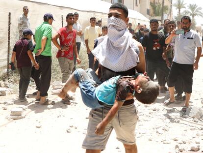 Un joven palestino trasladaba el viernes a un niño herido tras un ataque israelí sobre Deir Al-Balah, en la zona central de la franja de Gaza.