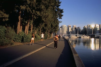 Gente paseando al borde de Coal Harbour, en el parque Dans Stanley de Vancouver (Canadá).
