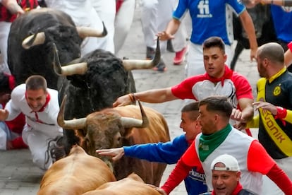 Los mozos son perseguidos por los toros de la ganadería de Domingo Hernández, durante el quinto encierro de los Sanfermines.
