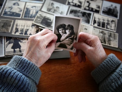 Una mujer observa una foto antigua de ella con su hija.