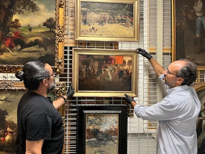 Dos conservadores de la Casa de Colón con el cuadro incautado a Pedro Rico, 'Cruz de mayo', de Eugenio Lucas, en una imagen facilitada por el Cabildo de Gran Canarias.