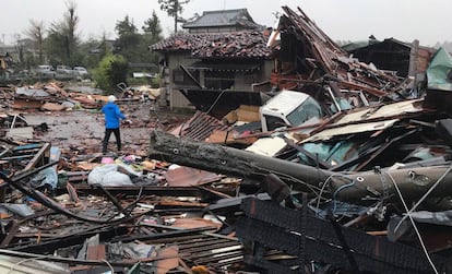 Un hombre camina por los escombros de varias casas desplomadas por el tifón Hagibis en Ichihara, al este de Tokio.