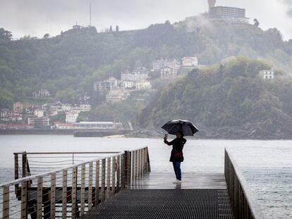 Una mujer se fotografía este martes con su paraguas en la pasarela del Náutico de San Sebastián.