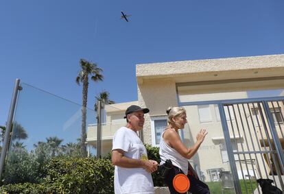 Dos vecinos de Urbanova con un avión al fondo.