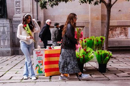 Dos chicas junto a un puesto con rosas en Barcelona, este martes.