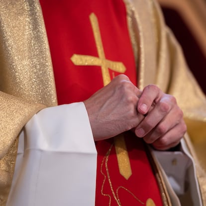 Hands of a Catholic priest in a cassock