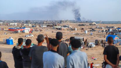 Varios palestinos observan desde la distancia los restos del ataque sobre la ciudad de Rafah, al sur de Gaza, este 28 de mayo.