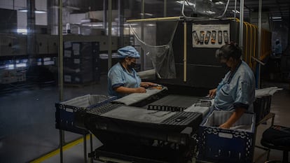 Trabajadoras colocan componentes de controles remotos en cajas en una fábrica en Tijuana (México), en septiembre de 2021.