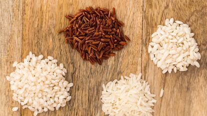 Four different kinds of rice on a wooden board: Carnaroli rice (Italy), Camargue red rice (France), Basmati long grain rice (India) and Bomba rice (Spain)