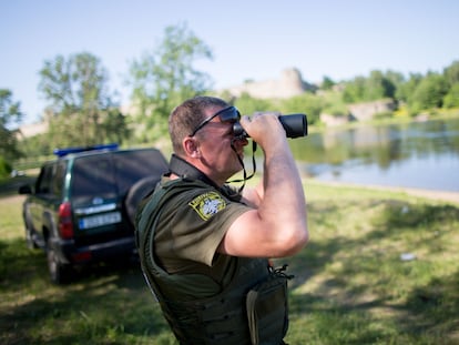 Un agente de fronteras de Estonia vigila la orilla rusa del río Narva en junio de 2016.