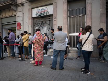 Personas frente a la Oficina de Prestaciones sociales del Ayuntamiento de Barcelona.