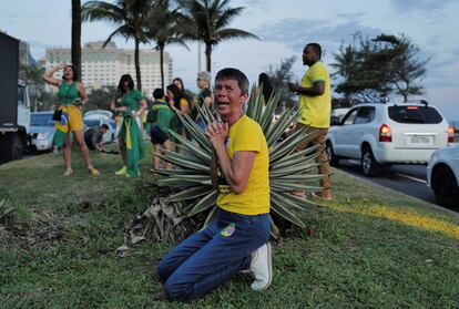 Una mujer llora de rodillas, reunida con otros seguidores del todavía presidente Bolsonaro, a las afueras de la residencia privada de Bolsonaro en Río. Existe una enorme expectación sobre si Bolsonaro aceptará la derrota o no.