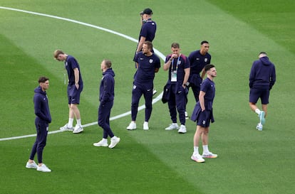 Jugadores y parte del cuerpo técnico inglés inspeccionan el terreno de juego. 