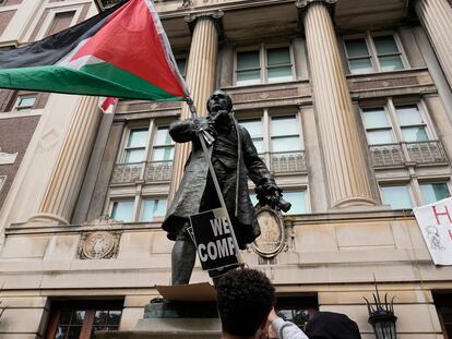 Un estudiante ondea una bandera palestina frente al edificio de la Universidad de Columbia ocupado por manifestantes.