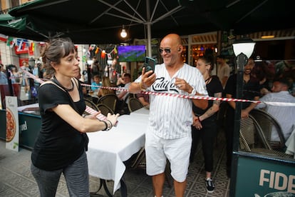 Una mujer precinta un restaurante de la Barceloneta ante el paso de la manifestación del pasado sábado..