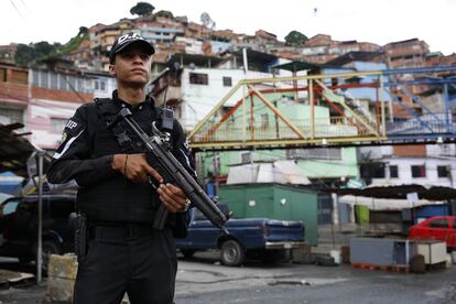 Un elemento de una unidad especial de la Policía Nacional monta vigila una de las calles principales del barrio Cota 905, en Caracas (Venezuela), en julio de 2021.