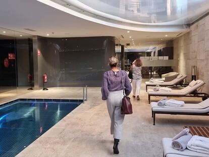 Dos mujeres caminan junto a la piscina interior de una de las promociones de vivienda de lujo en Madrid.