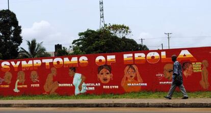 Un hombre camina frente a un mural sobre el ébola en Monrovia.