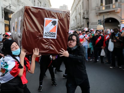 Manifestantes cargan una caja que representa un ataúd del partido político 'Acción Popular', en la Plaza San Martín en Lima (Perú), en 2020.