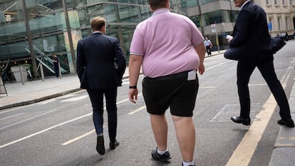 Unos hombres cruzan la calle en la City de Londres.