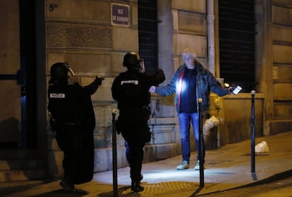 Dos policías identifican a un ciudadano cerca del lugar donde ha ocurrido el tiroteo.