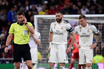 El árbitro Felix Brych en el partido de este martes. Detrás, los jugadores del Madrid Benzema (izquierda) y Kroos.