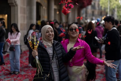 Dos mujeres tiran al aire pétalos de rosa frente a la Casa Batlló, este lunes en Barcelona.


