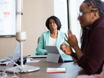 Una mujer ejecutiva dirige una reunión con su equipo de trabajo.