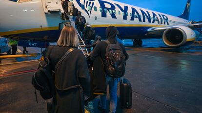 Un grupo de pasajeros sube, con equipaje de mano, a un avión de Ryanair en el aeropuerto de Dublín (Irlanda).
