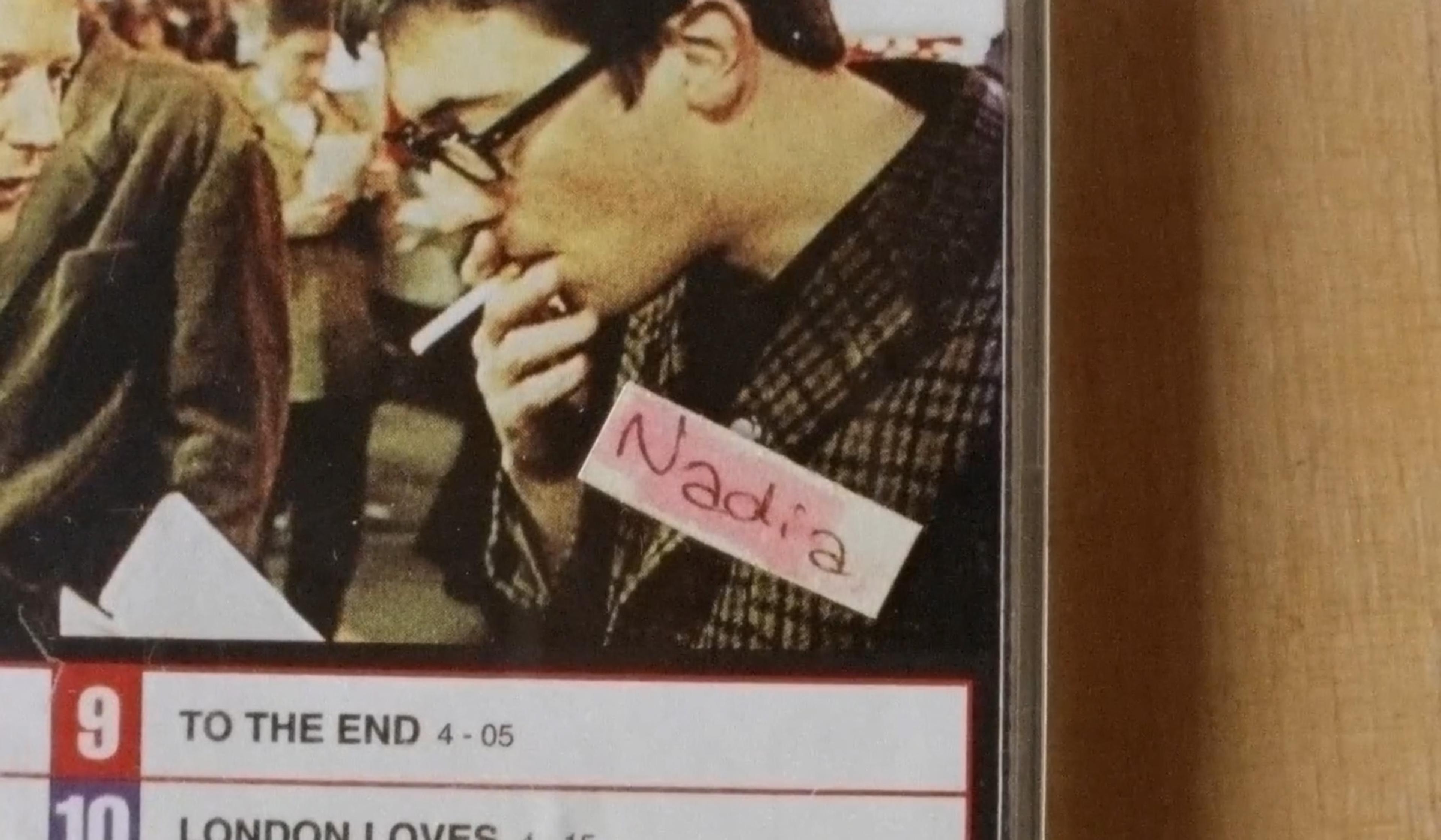 Close-up of mixtape labelled “Nadia” showing a man in glasses smoking, another person visible on the left, text listing songs at the bottom.