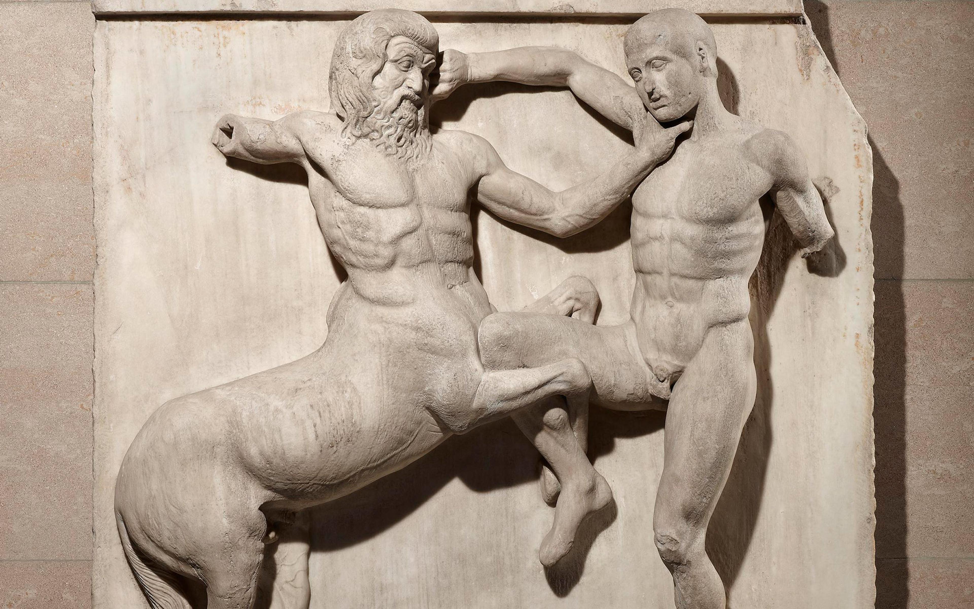 Ancient Greek marble relief of a centaur engaging in combat with a human, displaying intricate muscle details and dynamic movement on a stone background.