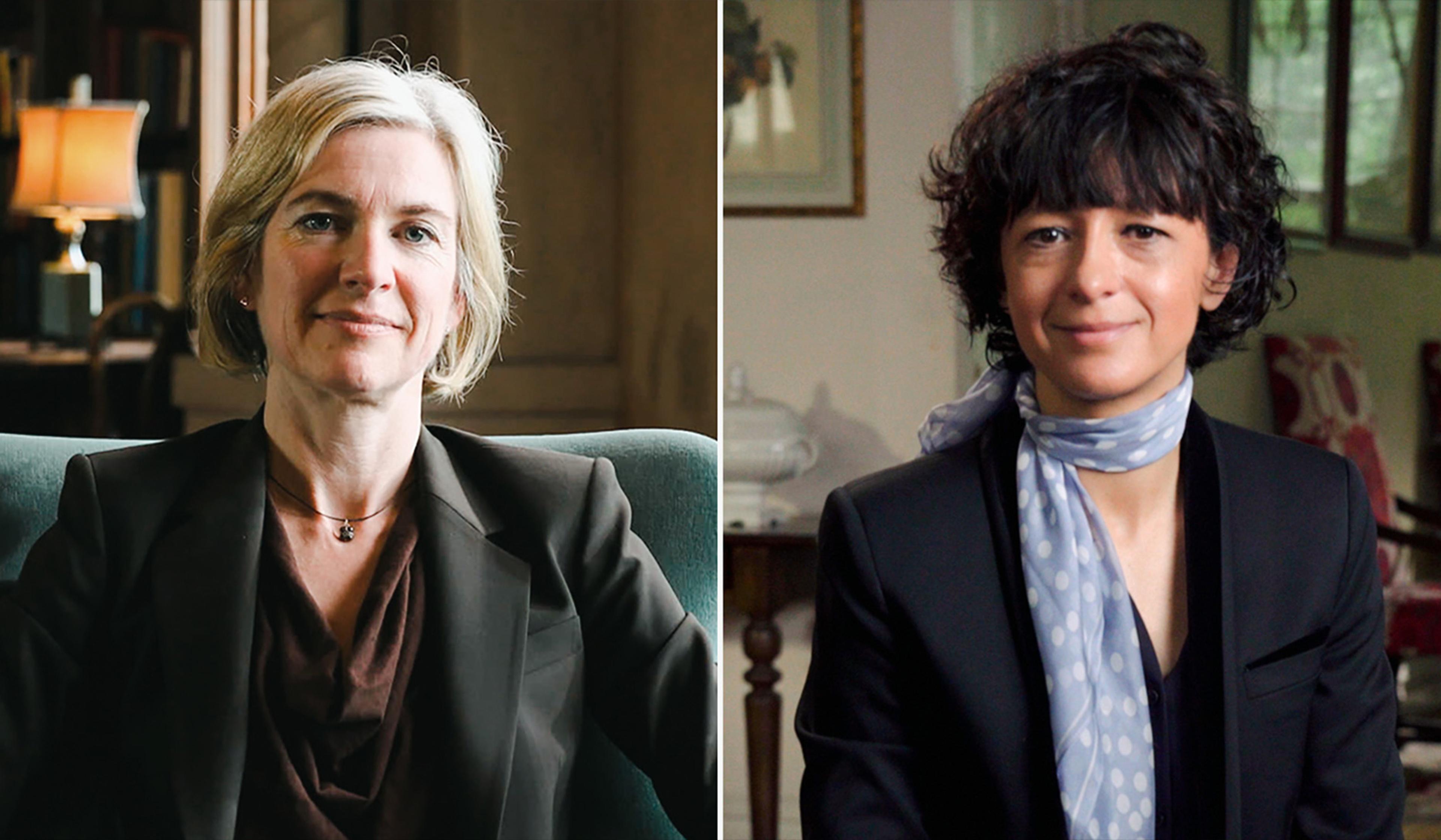 Two women in professional attire, one with short blonde hair sitting on the left, the other with dark curly hair and a scarf on the right, both indoors.