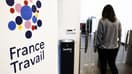 Une femme passe devant le logo de France Travail, le nouvel opérateur de service public de l'emploi, à Paris le 3 janvier 2024.