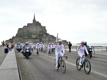 Les porteurs de flamme du relais olympique collectif cycliste au Mont-Saint-Michel (Manche), le vendredi 31 mai 2024.