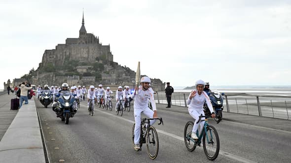 Les porteurs de flamme du relais olympique collectif cycliste au Mont-Saint-Michel (Manche), le vendredi 31 mai 2024.