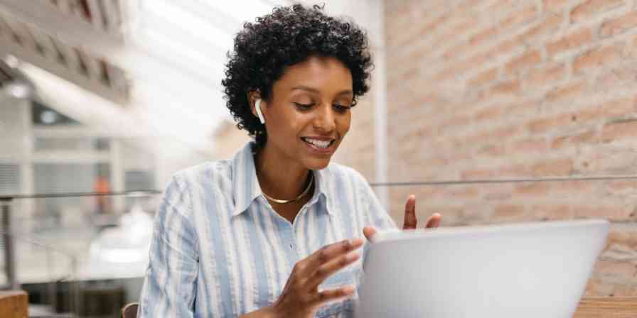 A hero image of a person working at a computer with earbuds in