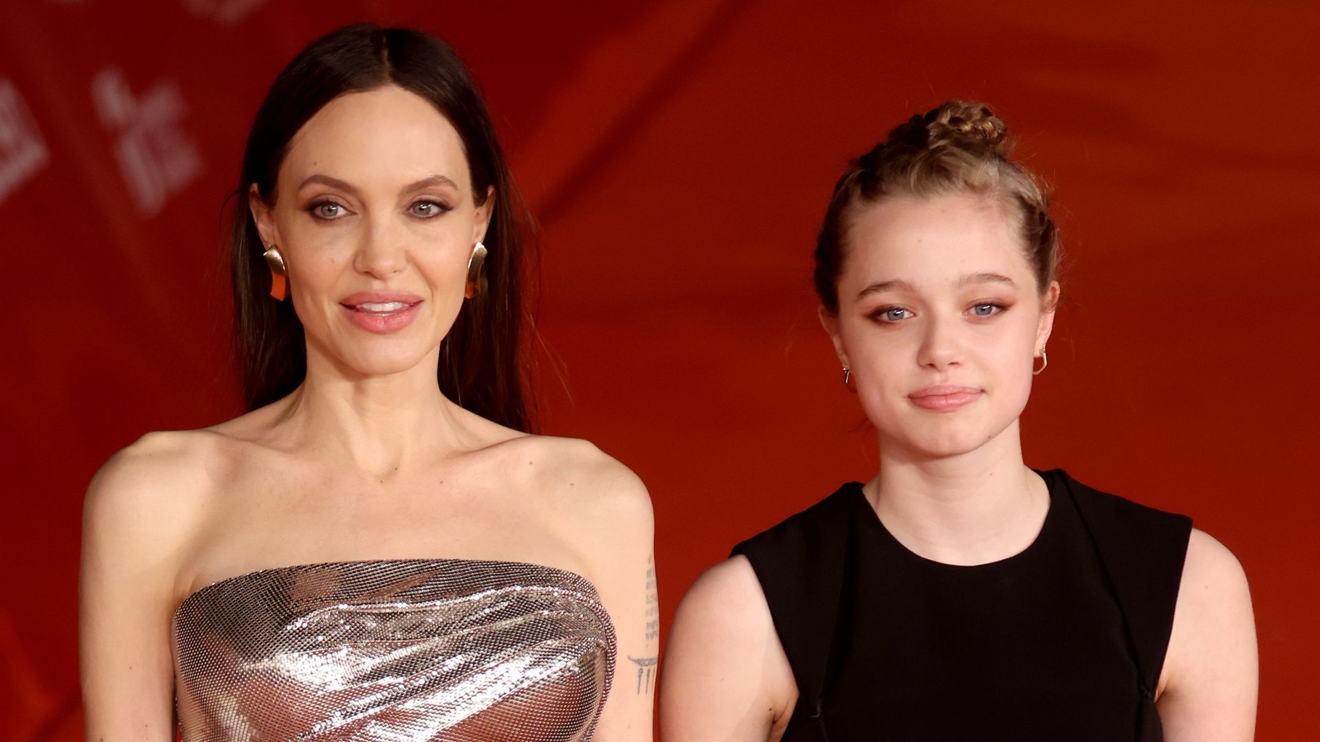 Shiloh Jolie Pitt and Angelina Jolie posing on the red carpet