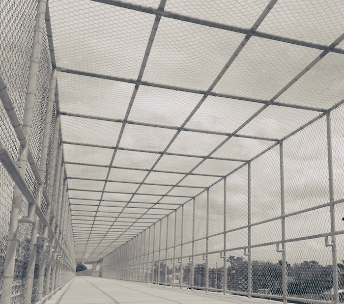 A bridge enclosed in wire fencing.