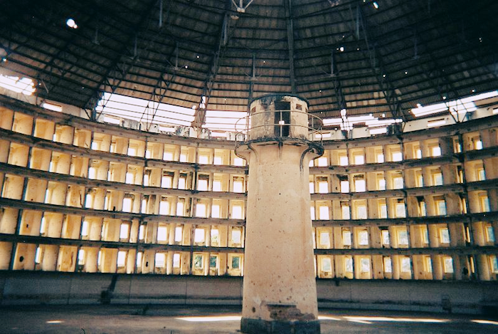 Photo of a panopticon prison with guard tower looming before dozens of cells.