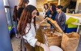 Students hand out pizza to those attending the student social