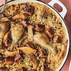 Une casserole remplie de saucisses, de poulet et de riz brun. 