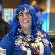 Portrait d'Anne Grossman, une perruque bleue sur la tête et un chandail pour la coupe Gray.